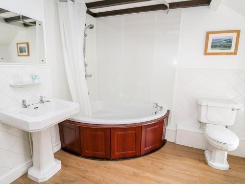y baño con bañera, aseo y lavamanos. en The Woodman en Llandrindod Wells