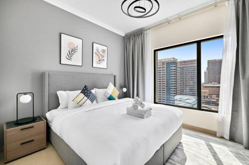 a bedroom with a large bed and a large window at StoneTree - Time Place Tower 1 BR - Amazing View in Dubai