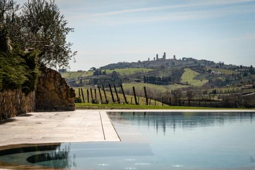 a swimming pool with a view of a hill at Mormoraia in San Gimignano