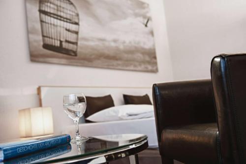 a table with a wine glass and a chair at Tryp by Wyndham Wuppertal in Wuppertal