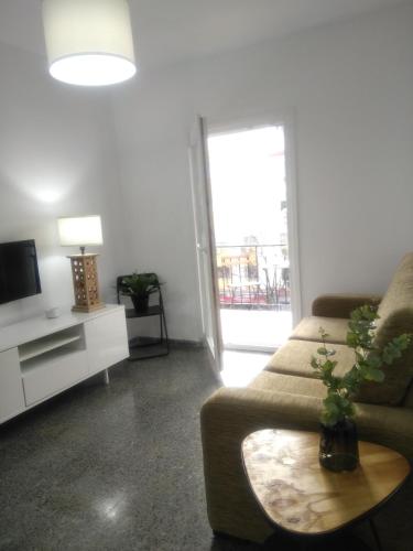 ein Wohnzimmer mit einem Sofa und einem TV in der Unterkunft Sevilla Macarena apartamento 3 dormitorios in Sevilla