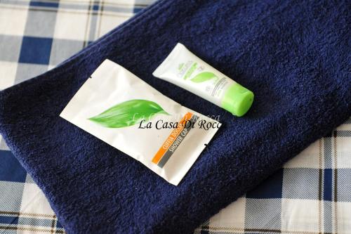 una bottiglia di lozione e un tubetto di dentifricio su un asciugamano blu di La Casa di Rocca a Castel di Sangro
