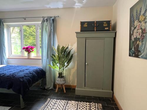 a bedroom with a bed and a cabinet with a suitcase on top at Healing Pastures Farm in Llanbrynmair