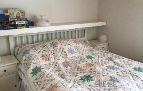 Una cama con edredón en un dormitorio en Gorgeous Home In Herrng With Kitchen en Herräng