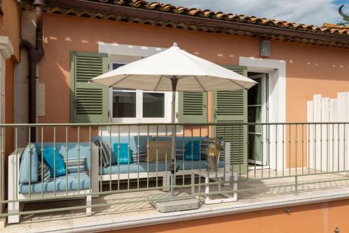 a balcony with chairs and an umbrella at Le Mouillage in Saint-Tropez
