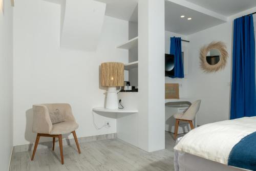 a bedroom with a bed and two chairs and a table at Le Mouillage in Saint-Tropez