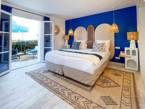 a bedroom with a large bed with blue walls at Le Mouillage in Saint-Tropez