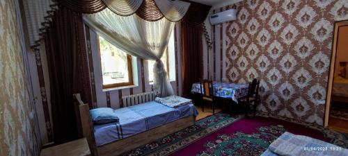 Un dormitorio con una cama pequeña y una ventana en Sezam, en Bukhara