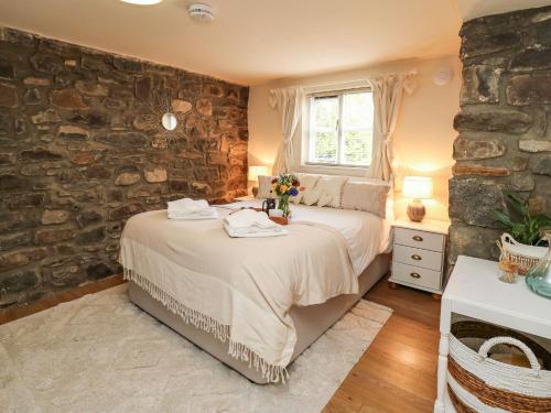a bedroom with a bed and a stone wall at The Middleton in Llandrindod Wells