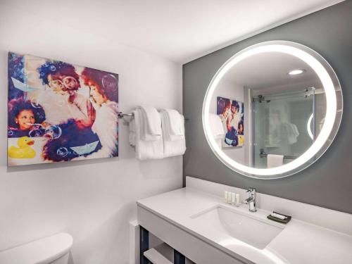 a bathroom with a sink and a mirror at La Quinta by Wyndham Chicago O'Hare Airport in Rosemont