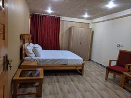 een slaapkamer met een bed en een rood gordijn bij Heavess Peak Hotel in Muzaffarabad