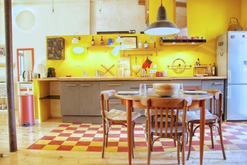 d'une cuisine avec une table, des chaises et des murs jaunes. dans l'établissement Artistic Loft, Downtown Montpellier, WIFI, à Montpellier
