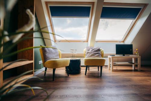 a room with two chairs and a table and two windows at Buitenplaats de Luwte in Zwolle