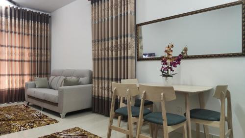 een woonkamer met een tafel en stoelen en een bank bij KONDO 2 BILIK ALANIS RESIDENCE KOTA WARISAN in Sepang