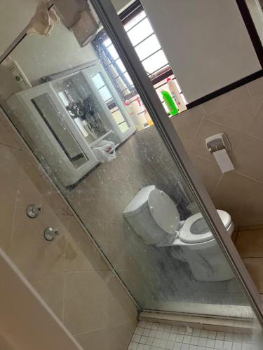 a bathroom with a toilet through a glass door at Via Vercelli in Sandton