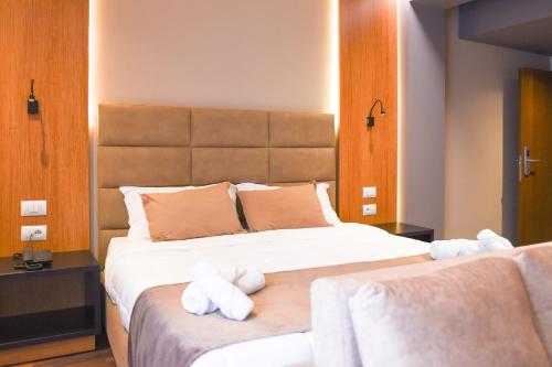 a bedroom with a large bed with stuffed animals on it at Olivia's Hill Resort in Durrës
