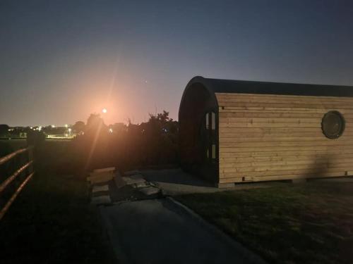a building with the sun setting in the background at Spring Tide Cliff Top Glamping Pod with direct Sea Views in Birchington