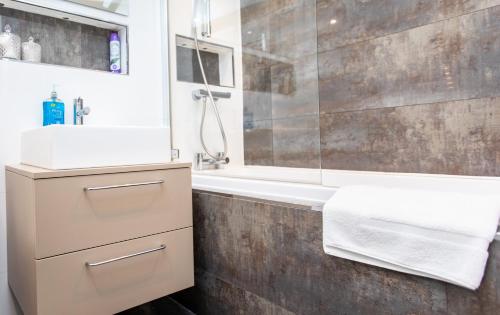 a bathroom with a sink and a shower and a tub at The Ilkley Hideaway in Ilkley