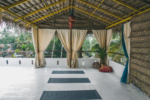 Habitación con alfombras en el suelo y ventanas en Boho's Hotel, en Varkala