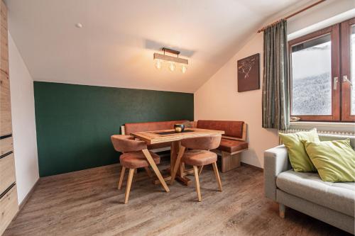 a dining room with a table and a couch at Haus Hoen in Untertweng