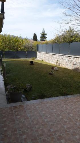 a yard with a stone fence and a grassy field at B&B Villa Chiara - Bed And Breakfast in Taormina