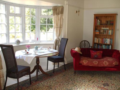 a living room with a table and a couch at The Old Vicarage Bed And Breakfast in Hindolveston
