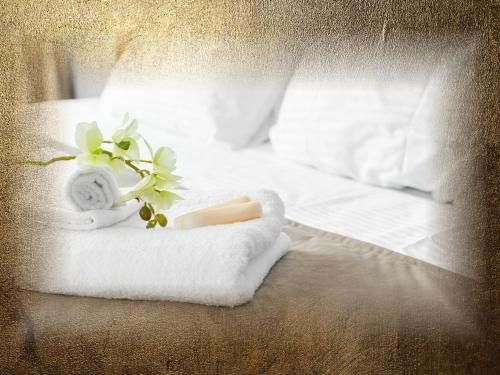 a bed with towels and a candle and flowers on it at Burg-Hotel & Hostel Cochem in Cochem