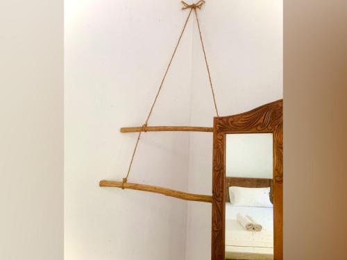 a mirror with a wooden frame hanging on a wall at Vinu’s Place in Matara
