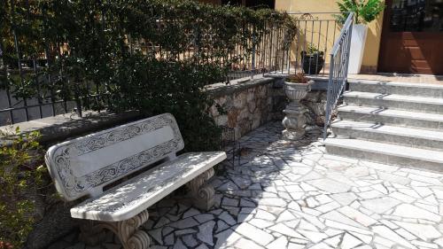 un banc en pierre assis à côté d'un escalier dans l'établissement B&B Villa Chiara Bed and Breakfast, à Taormine