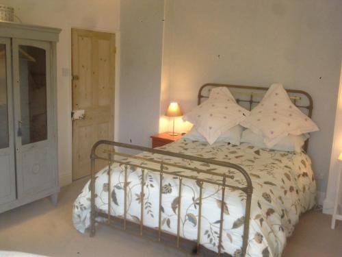 a bedroom with a bed with white sheets and pillows at The Old Vicarage Bed And Breakfast in Hindolveston