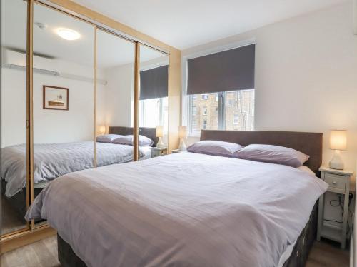 a bedroom with two beds and a large window at Sherwood Apartment in Margate