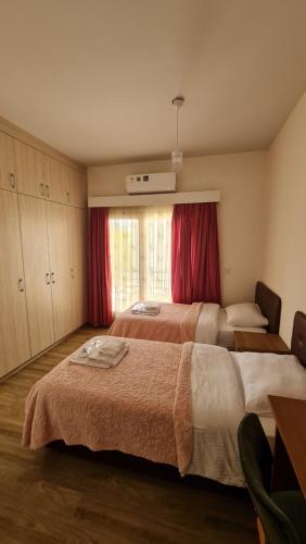 1 Schlafzimmer mit 2 Betten und einem Fenster mit roten Vorhängen in der Unterkunft Oytam apt in Nikosia