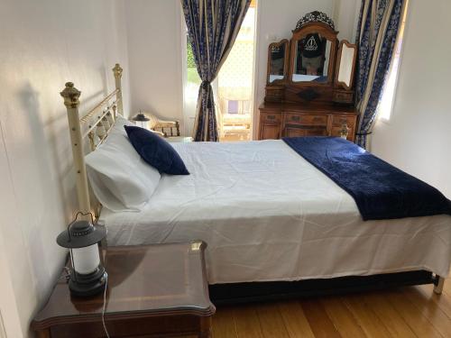 1 dormitorio con 1 cama, vestidor y reloj en The Old Station Masters House, en Maryborough