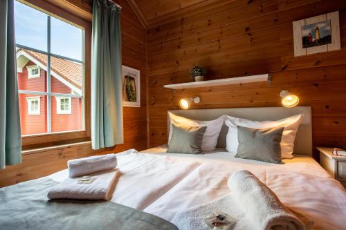 - une chambre avec un grand lit et une grande fenêtre dans l'établissement Typ D "Midsummer" -Schärenhaus-, à Pelzerhaken