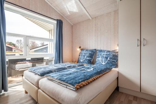 een slaapkamer met een bed en een groot raam bij Strandpark 43 in Grömitz
