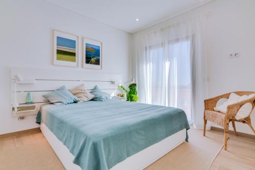a white bedroom with a bed and a chair at FormosaTavira Seaview @Homesbyfc in Tavira