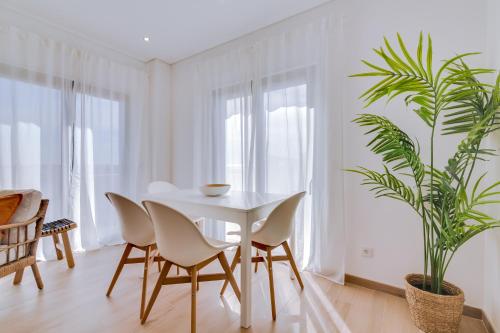 a white dining room with a white table and chairs at FormosaTavira Seaview @Homesbyfc in Tavira