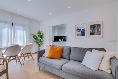 a living room with a gray couch and a table at FormosaTavira Seaview @Homesbyfc in Tavira