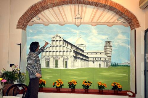 a woman painting a picture of a building at Hotel Leonardo in Pisa