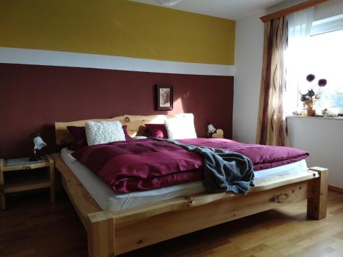 a bedroom with a wooden bed with purple sheets at Ferienwohnungen Christa Grabmeier in Grainet