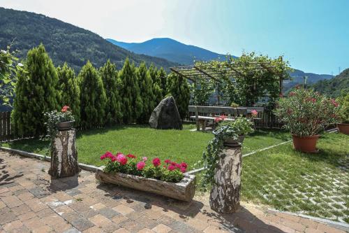 a garden with flowers and a bench and mountains at Bachmannhof in Feldthurns