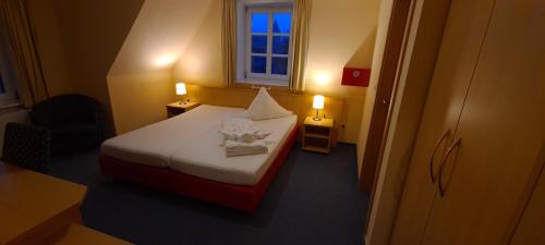 DrakenburgにあるEphesus am Weserwehrのベッドと窓が備わる小さな客室です。