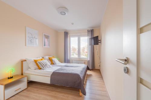 a small bedroom with a bed and a window at Pool & Leisure Apartament Polanki Park in Kołobrzeg