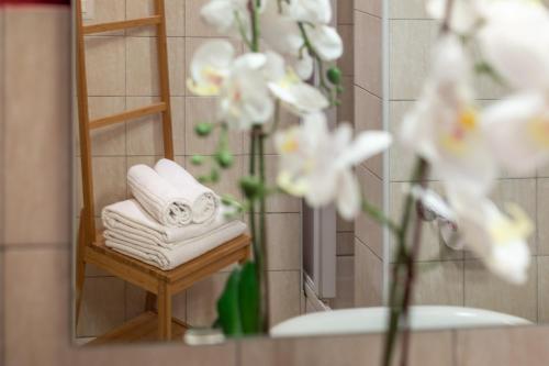 a bathroom mirror with towels and a vase of flowers at Wine Apartments Florence Pinot in Florence