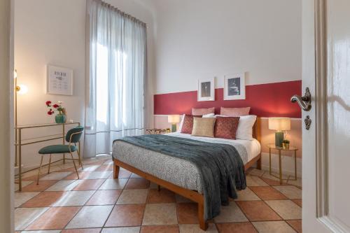 a bedroom with a large bed with a red wall at Wine Apartments Florence Pinot in Florence