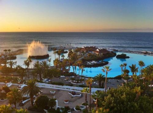 a view of a resort with a fountain and the ocean at Tommy apartamento centro del puerto de la cruz y de la playa in Puerto de la Cruz