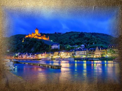 a town with a castle on top of a hill at Burg-Hotel & Hostel Cochem in Cochem