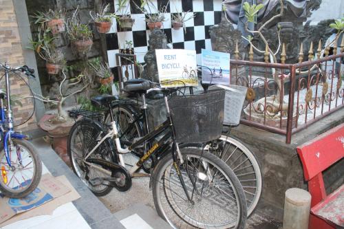 two bikes parked next to a fence with a basket at Chillin Kuta Homestay in Kuta