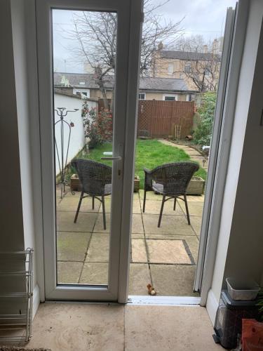 an open door to a patio with a table and chairs at Best Location! Town & Racecourse! in Cheltenham