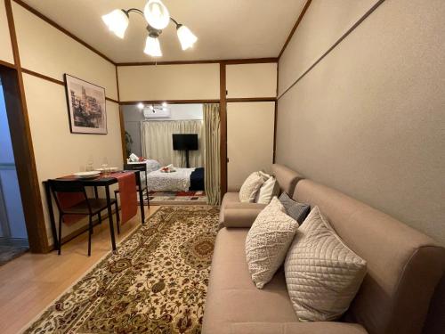 a living room with a couch and a table at Best Shinjuku Modern Full-furnished Family size Apartment4 ONLY 2min to Shinjuku by Train in Tokyo